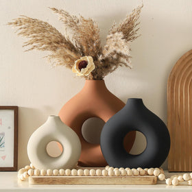 Vanselia hollow donut ceramic vase in rust adds modern flair to any room.