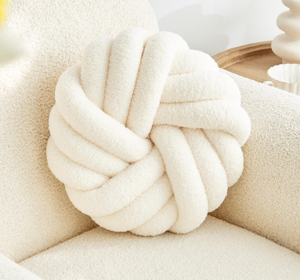 Vdoioe knot pillow in cream white round shape adds soft comfort to sofas.