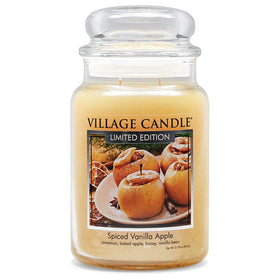 Village Candle Spiced Vanilla Apple glass jar glows to create cozy living room ambiance.