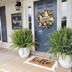 Vofuly white floral wreath with boxwood leaves enhances porch decor.