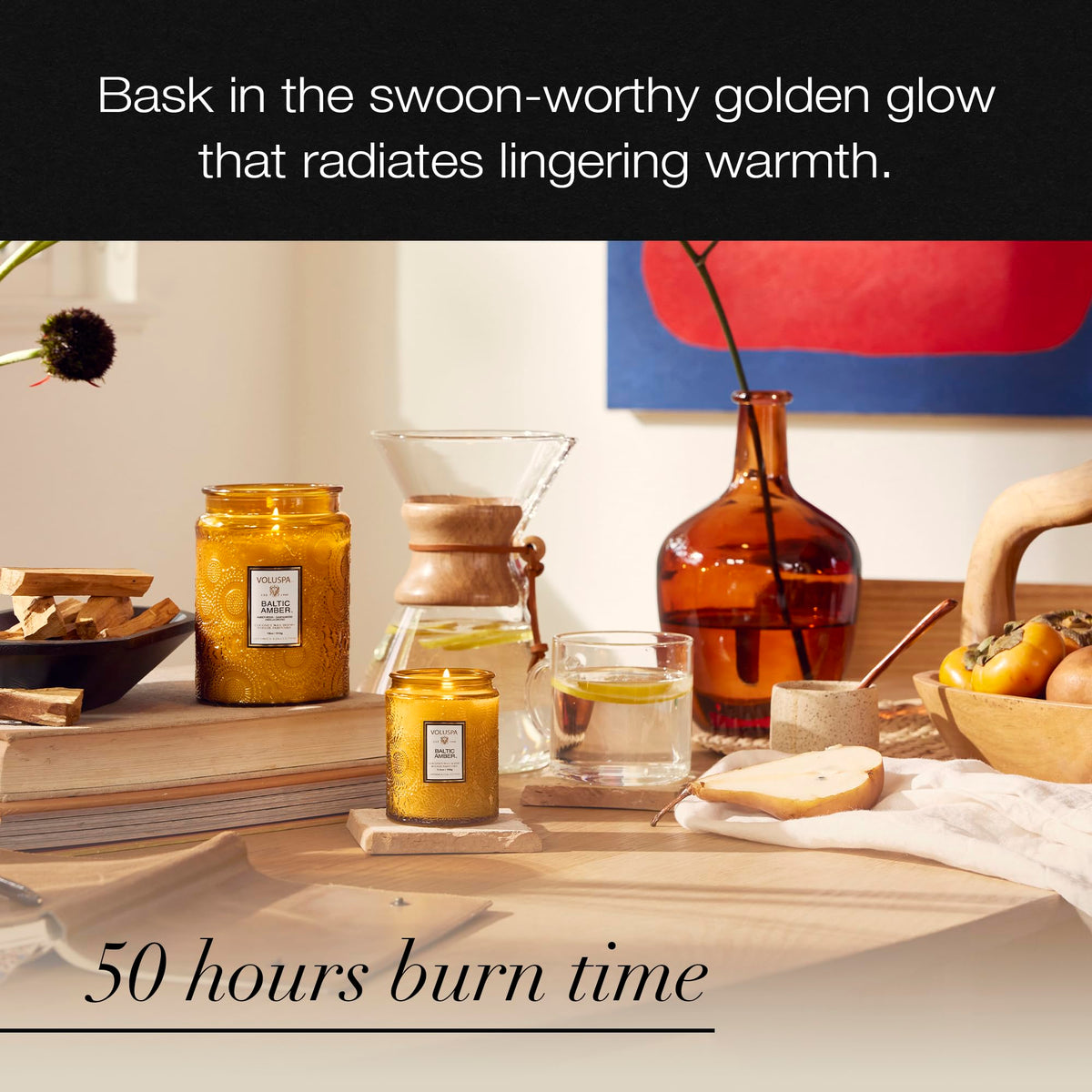 Voluspa Baltic Amber candle casts a soft glow on table decor.