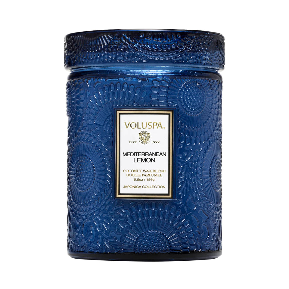 Voluspa Mediterranean Lemon candle jar releasing a bright citrus aroma in a cozy room.