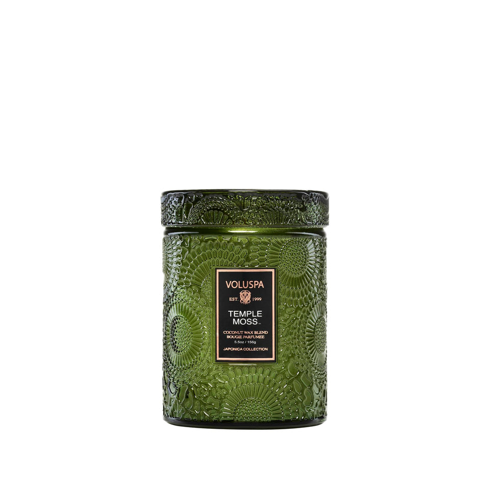 Voluspa Temple Moss glass jar candle shown with earthy notes for a calming home ambiance.