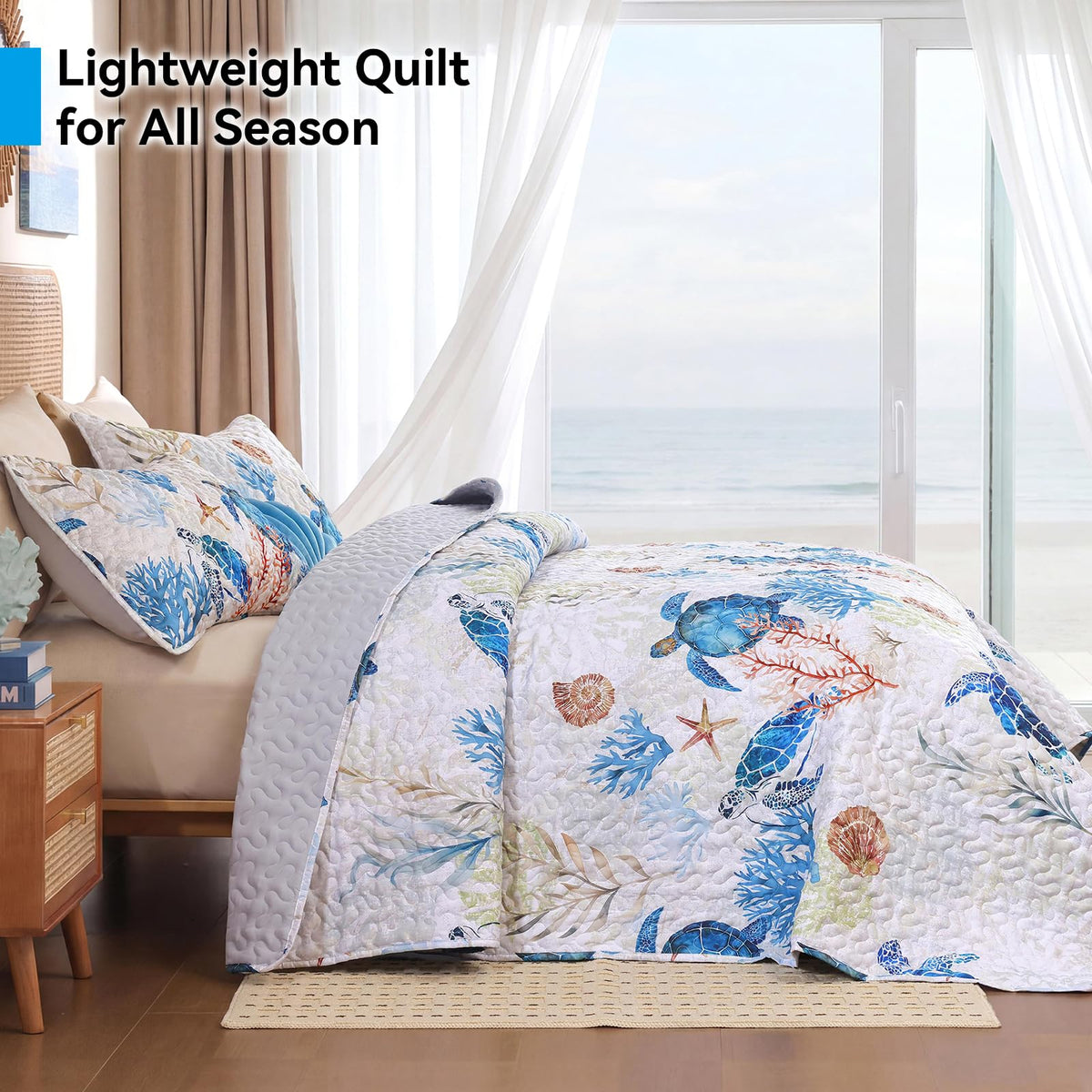 Weigelia coastal quilt with coral prints adds a seaside accent to the room.
