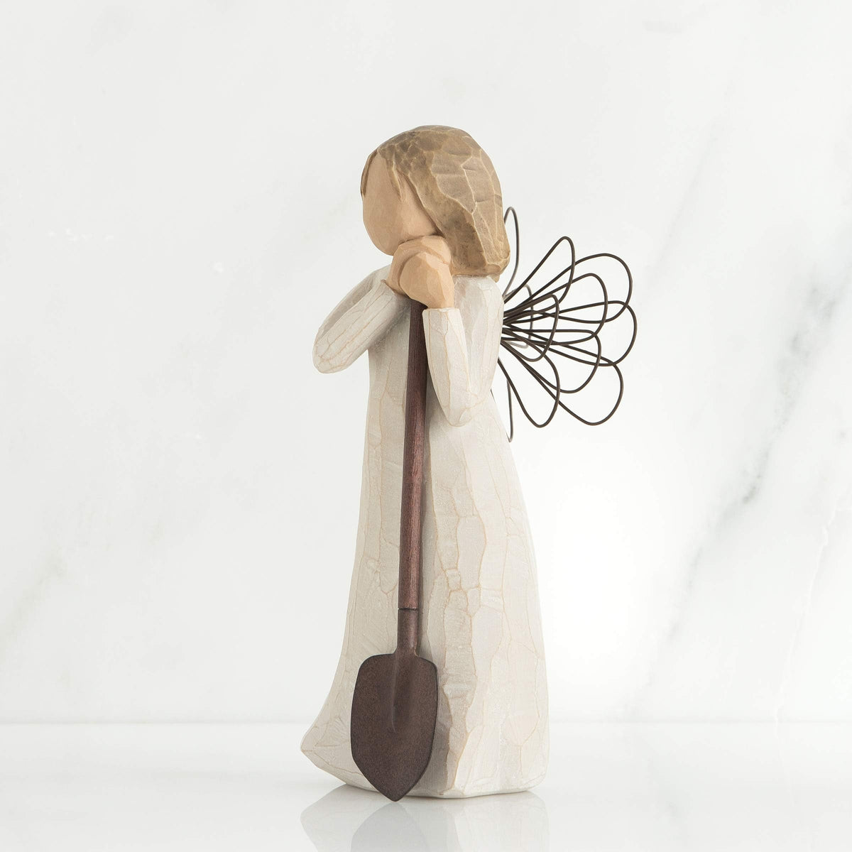 Willow Tree Angel holding a brown shovel, perfect for gardeners.