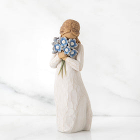 Willow Tree Forget-me-not blue bouquet up to her face, creates a tender sympathy mood