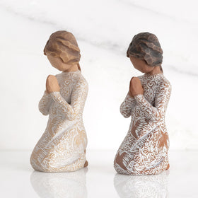 Darker skin Willow Tree figure displayed on a shelf for quiet reflection.