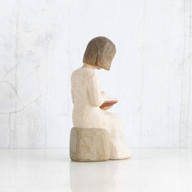 Willow Tree Wisdom figure on a mantel with gray rock display.