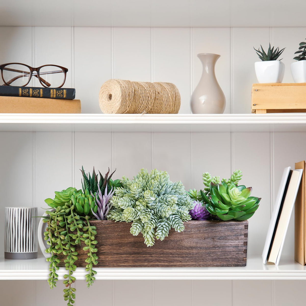 Winlyn artificial succulent display on a coffee table with pebble accents adds year-round greenery.