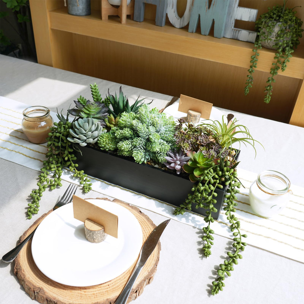Rectangular black wooden planter showcases lifelike succulents for tabletop display.