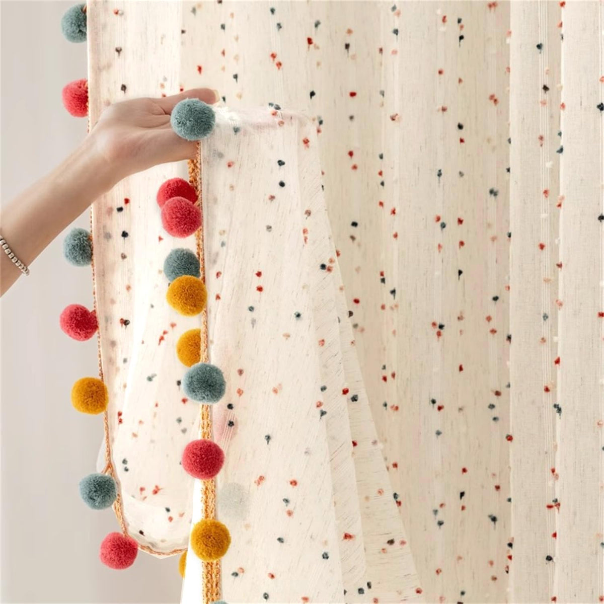 WJLQLM boho rainbow sheer curtain with pom pom accents softly diffuses light.