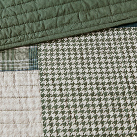 Woolrich Mill Creek quilt with navy accents elevates a calm, lodge-inspired bedroom.