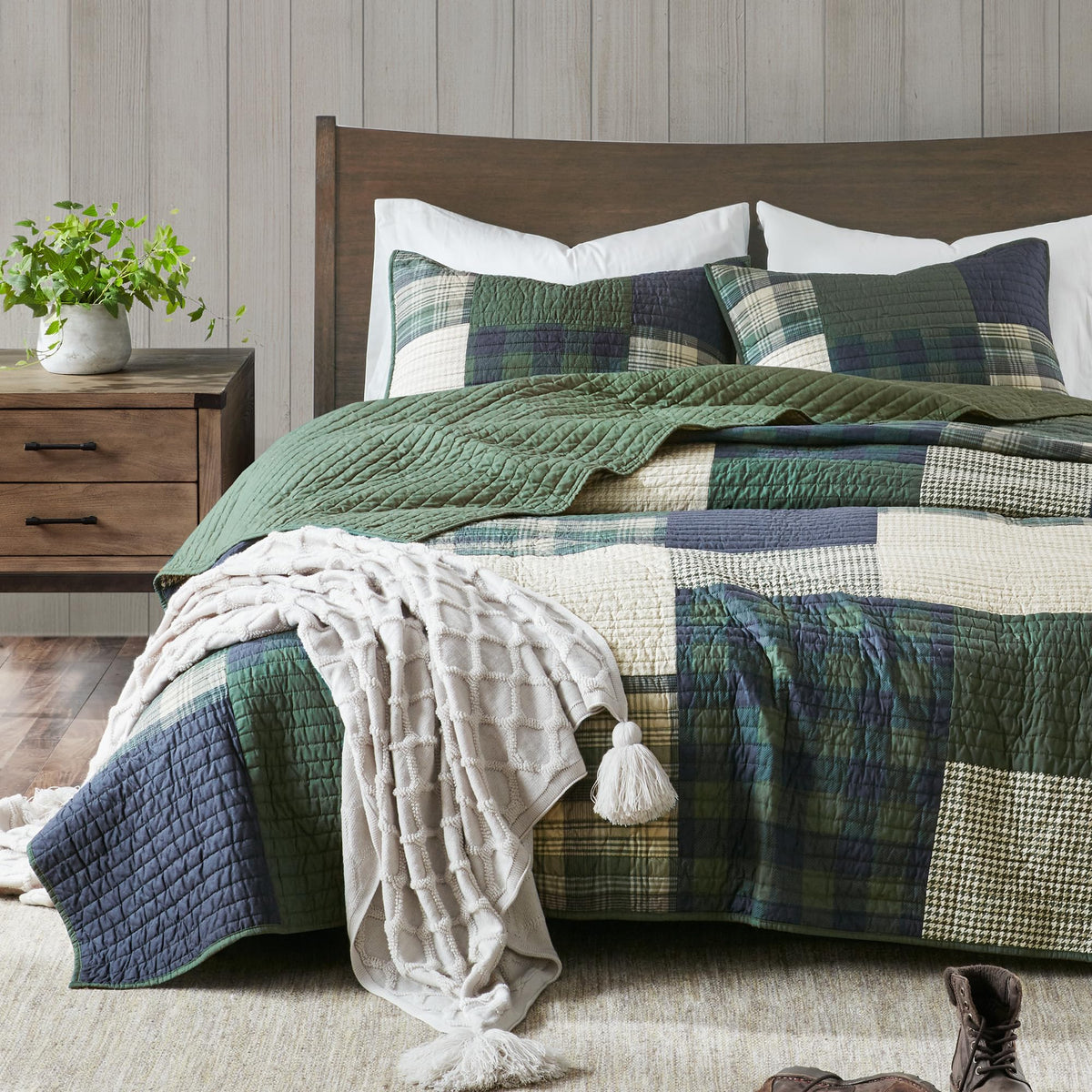 Woolrich Mill Creek patchwork quilt close-up in green and navy for cozy cabin vibe.