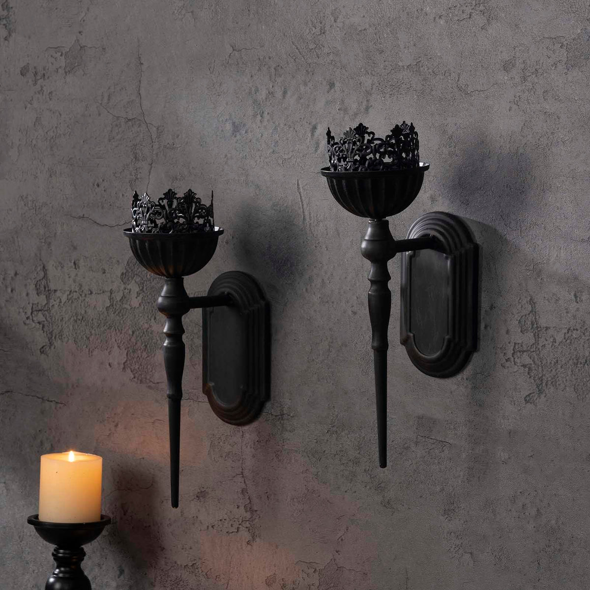 Hanging iron wall sconce in matte black complements rustic and modern interiors.
