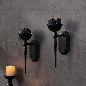 Hanging iron wall sconce in matte black complements rustic and modern interiors.