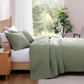 WRENSONGE bed setup showcases refined, modern look with sage green quilt.