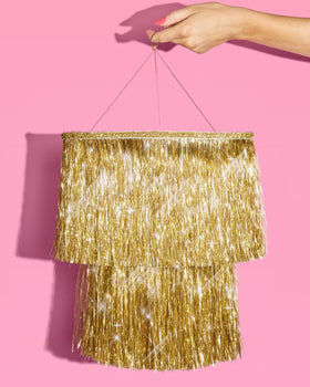 xo Fetti gold fringe chandelier above a dessert table