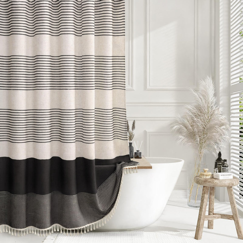 XOGUIBO black shower curtain with boho striped tassels for warm bathroom style.