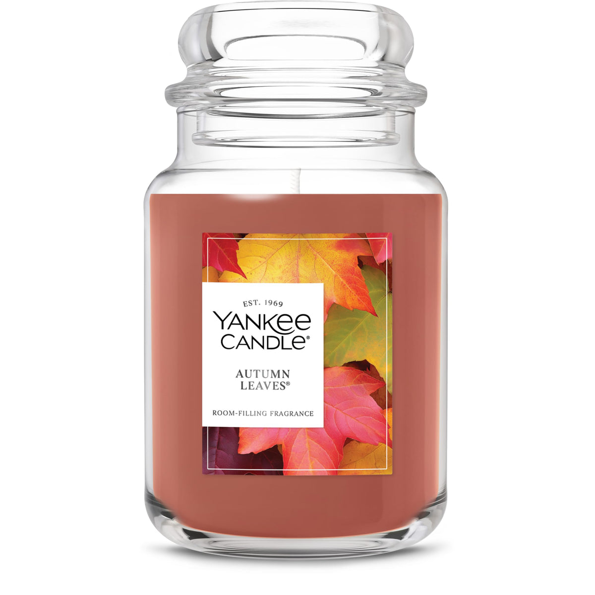 Yankee Candle Autumn Leaves 22oz jar with label close-up, cozy autumn ambiance for living rooms.