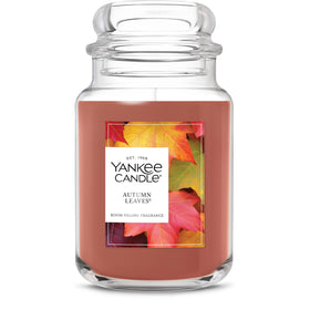 Yankee Candle Autumn Leaves 22oz jar with label close-up, cozy autumn ambiance for living rooms.