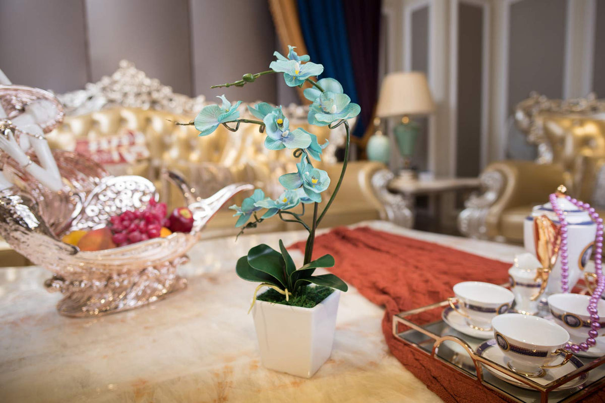 YSZL Silk leaves accompany the teal orchid for a vibrant, year-round decor accent